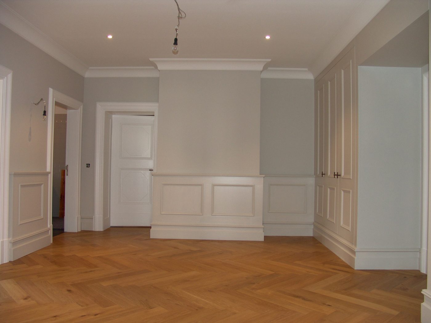 Raum mit Wandvertäfelung und Parkett nach dem Umbau
